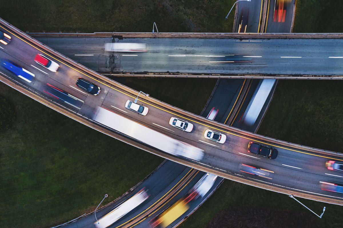 A photo from above of traffic moving quickly on three intersecting highways. 